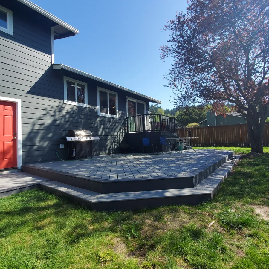 Custom Decks ground level deck wrap around steps trex pebble gray trex winchester gray accent trex railing signature in black enclosed upper deck bothell washington